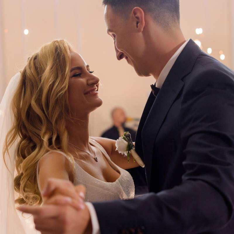 side-view-smiled-young-married-couple-celebrating-their-wedding-holding-hands-dancing